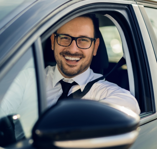 Mann mit Brille beim Autofahren.